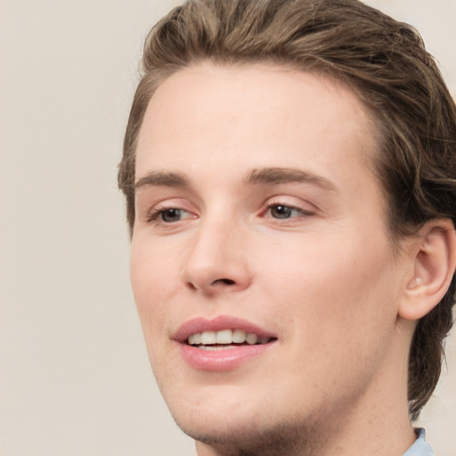 Joyful white young-adult male with medium  brown hair and green eyes