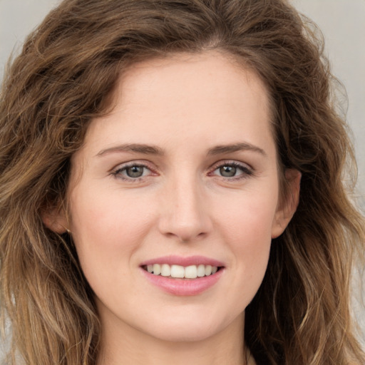 Joyful white young-adult female with long  brown hair and green eyes