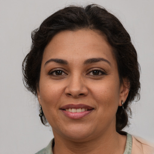 Joyful latino adult female with medium  brown hair and brown eyes