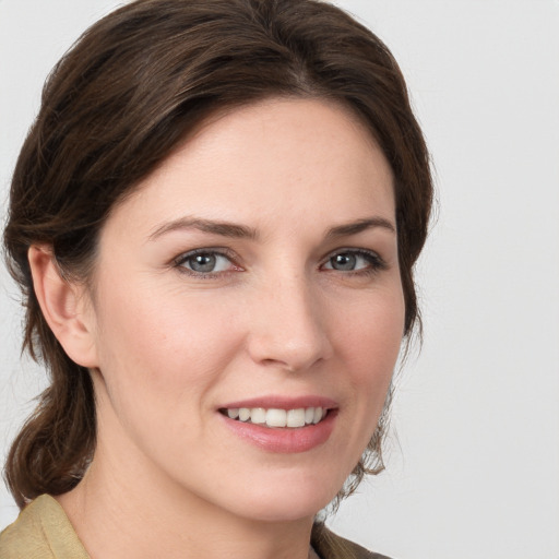 Joyful white young-adult female with medium  brown hair and blue eyes