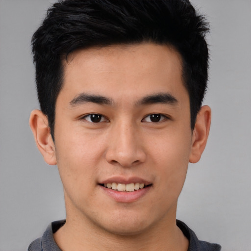 Joyful asian young-adult male with short  black hair and brown eyes