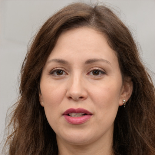Joyful white adult female with long  brown hair and brown eyes