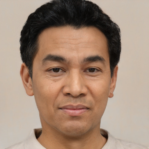 Joyful asian adult male with short  black hair and brown eyes