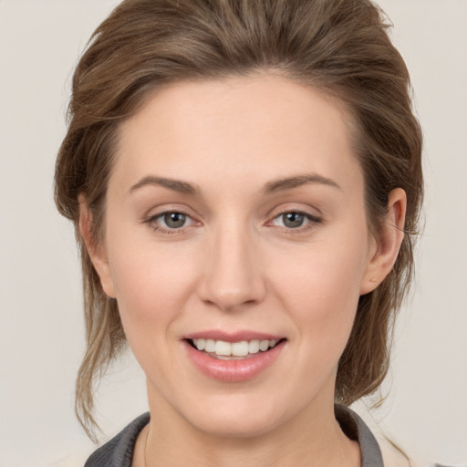 Joyful white young-adult female with medium  brown hair and grey eyes