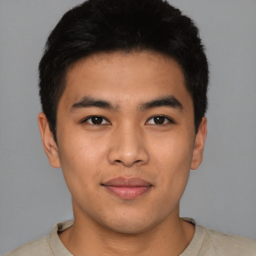Joyful latino young-adult male with short  black hair and brown eyes