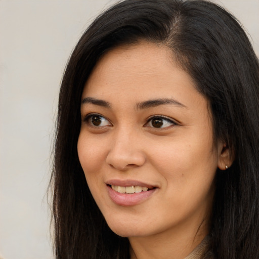 Joyful asian young-adult female with long  brown hair and brown eyes