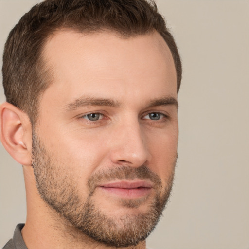 Joyful white young-adult male with short  brown hair and grey eyes