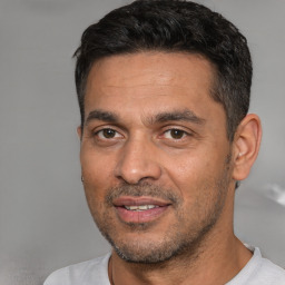 Joyful white adult male with short  black hair and brown eyes