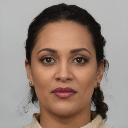 Joyful latino adult female with medium  brown hair and brown eyes