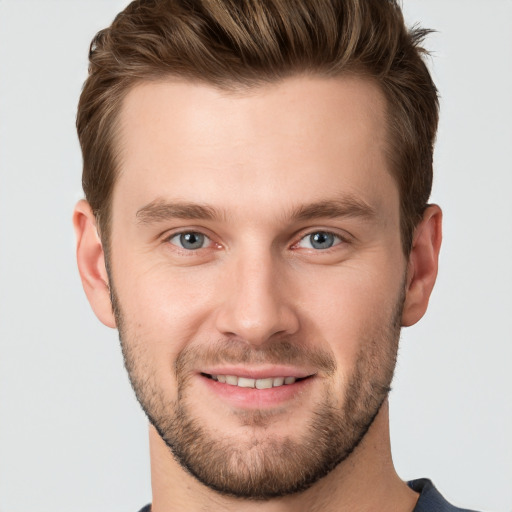 Joyful white young-adult male with short  brown hair and grey eyes