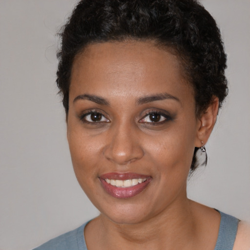 Joyful black young-adult female with short  black hair and brown eyes
