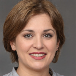 Joyful white young-adult female with medium  brown hair and grey eyes