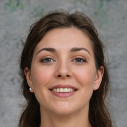 Joyful white young-adult female with medium  brown hair and grey eyes