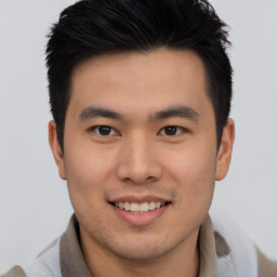 Joyful asian young-adult male with short  brown hair and brown eyes