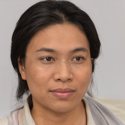 Joyful asian adult female with medium  brown hair and brown eyes