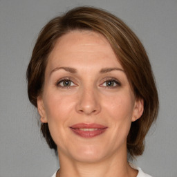 Joyful white adult female with medium  brown hair and grey eyes