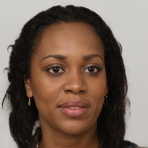 Joyful black adult female with long  brown hair and brown eyes