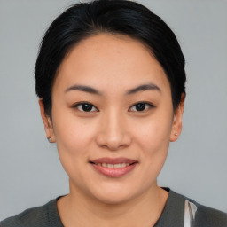 Joyful asian young-adult female with short  black hair and brown eyes