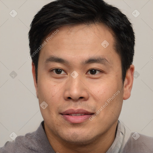 Joyful asian young-adult male with short  brown hair and brown eyes