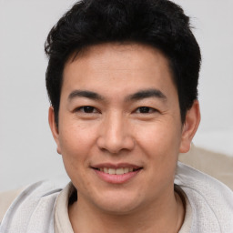 Joyful asian young-adult male with short  brown hair and brown eyes