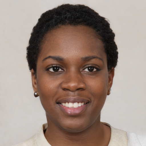 Joyful black young-adult female with short  black hair and brown eyes