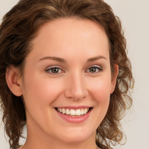 Joyful white young-adult female with medium  brown hair and green eyes