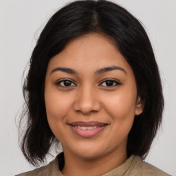 Joyful latino young-adult female with medium  brown hair and brown eyes