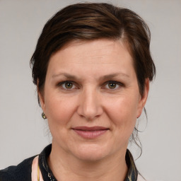 Joyful white adult female with medium  brown hair and grey eyes