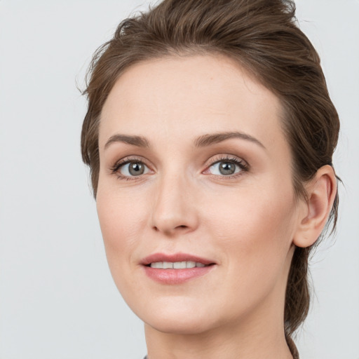 Joyful white young-adult female with medium  brown hair and grey eyes