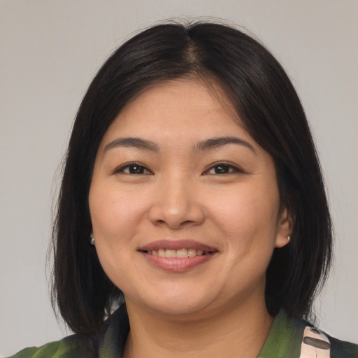 Joyful asian young-adult female with medium  brown hair and brown eyes