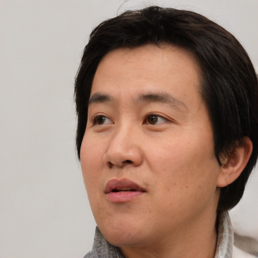 Neutral asian adult male with medium  black hair and brown eyes