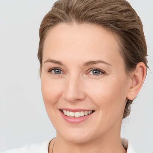 Joyful white young-adult female with medium  brown hair and grey eyes