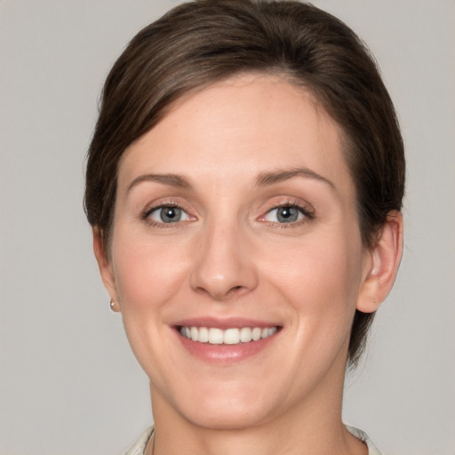 Joyful white young-adult female with short  brown hair and grey eyes