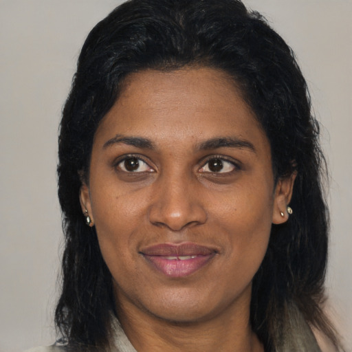 Joyful black adult female with medium  brown hair and brown eyes