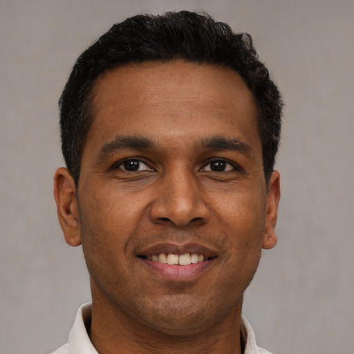 Joyful black adult male with short  brown hair and brown eyes