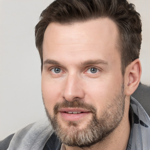 Joyful white adult male with short  brown hair and brown eyes