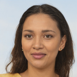 Joyful latino young-adult female with long  brown hair and brown eyes