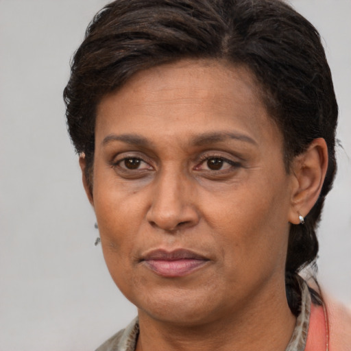 Joyful latino adult female with short  brown hair and brown eyes