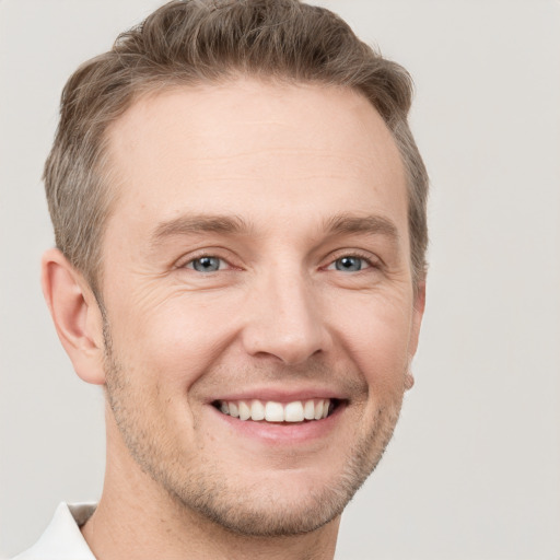 Joyful white adult male with short  brown hair and grey eyes