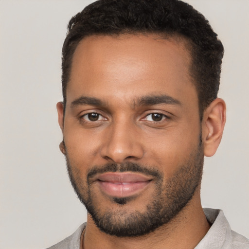 Joyful black young-adult male with short  black hair and brown eyes