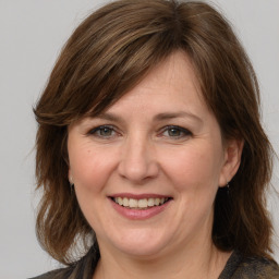 Joyful white adult female with medium  brown hair and grey eyes