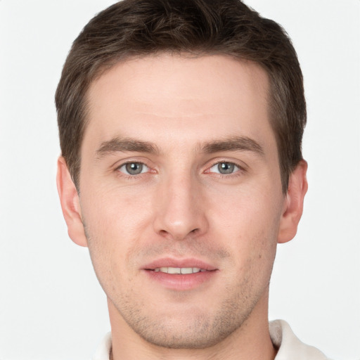 Joyful white young-adult male with short  brown hair and grey eyes