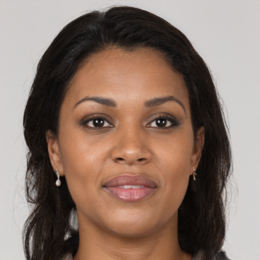 Joyful black young-adult female with long  brown hair and brown eyes
