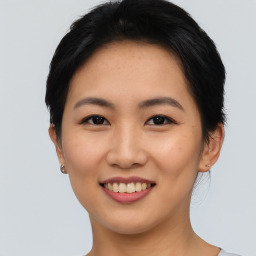 Joyful asian young-adult female with short  brown hair and brown eyes