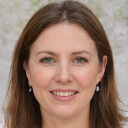 Joyful white adult female with long  brown hair and grey eyes