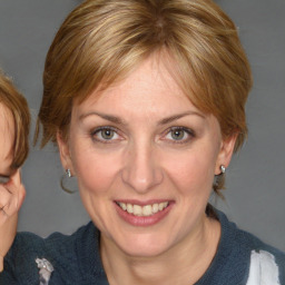 Joyful white adult female with medium  brown hair and blue eyes