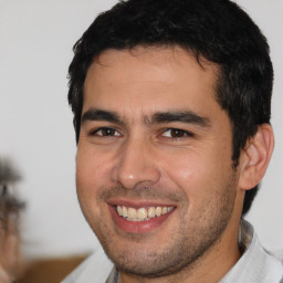 Joyful white young-adult male with short  black hair and brown eyes