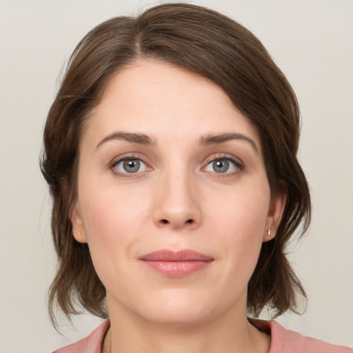 Joyful white young-adult female with medium  brown hair and green eyes