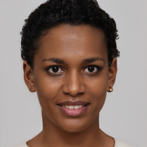 Joyful black young-adult female with short  black hair and brown eyes