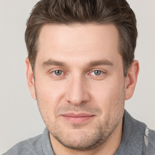 Joyful white adult male with short  brown hair and brown eyes